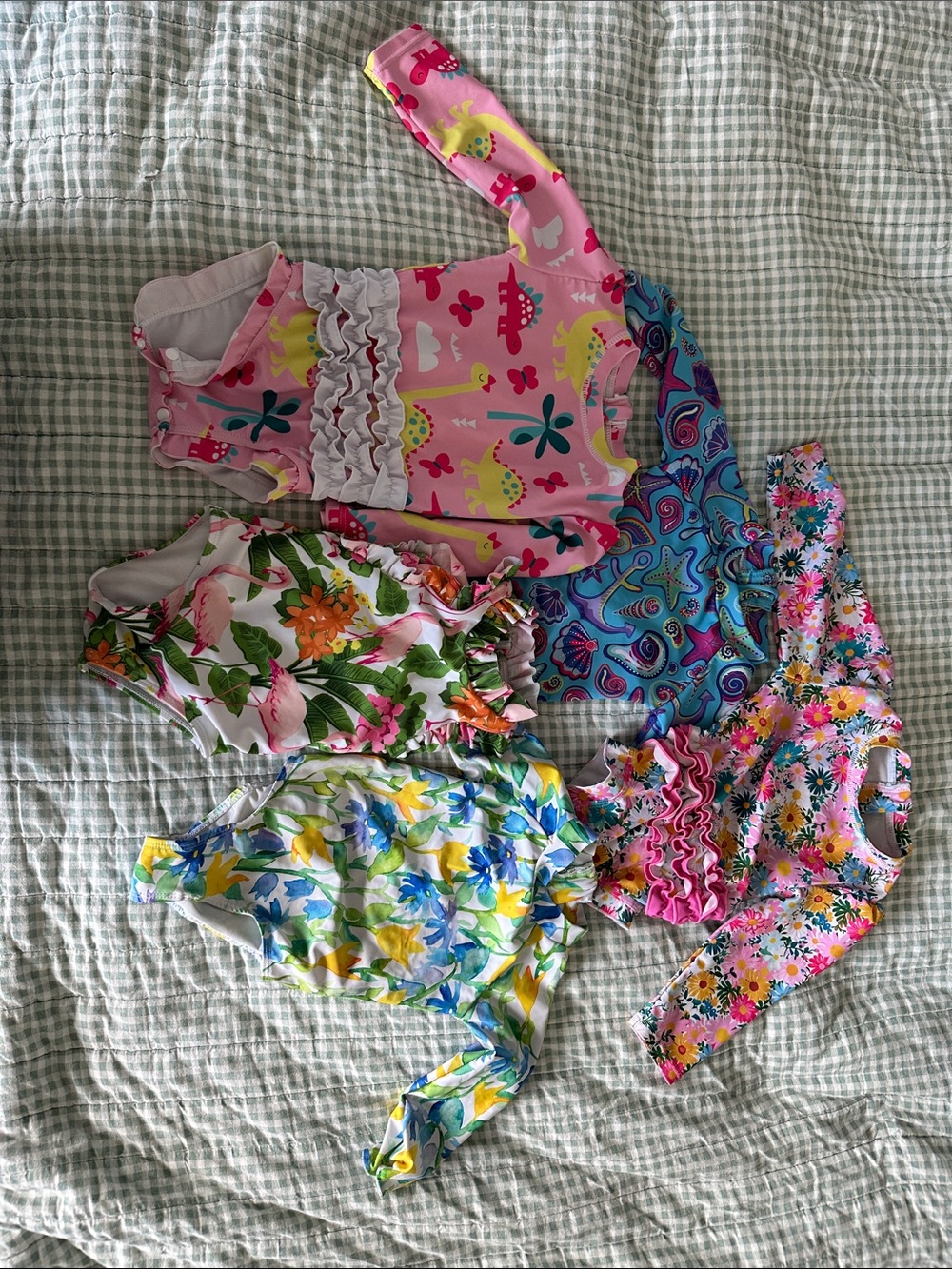5 one piece swimsuits 12-18m. 4 long sleeve, 1 sleeveless